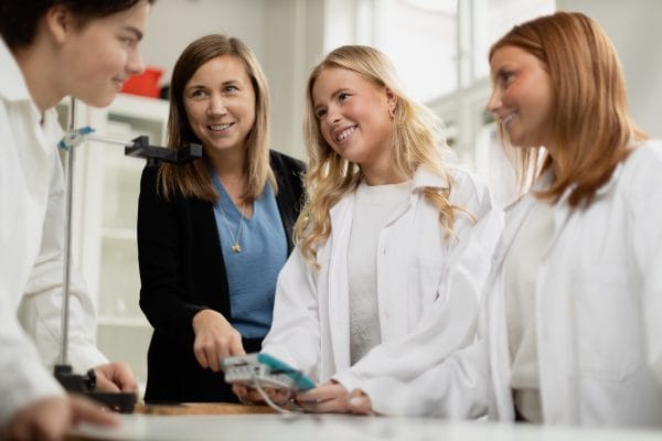 Elever genomför en laboration tillsammans med en lärare.