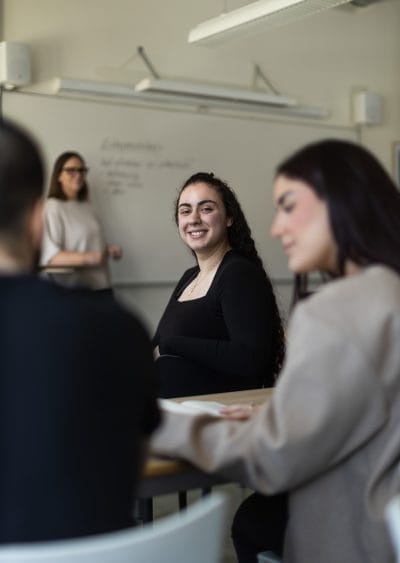 Elev har lektion i ekonomi och tittar bak på sin kompis.