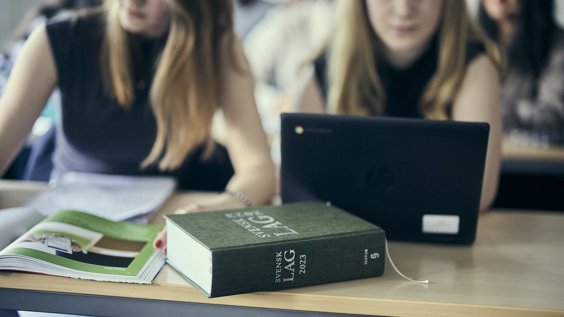 Studenter läser juridik och använder datorer.