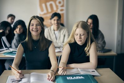 Elever studerar i klassrummet, fokuserade och engagerade.