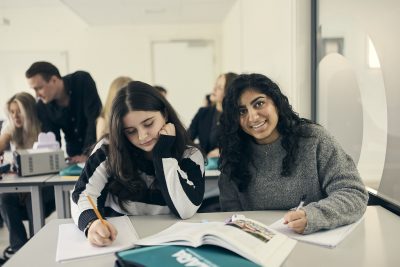Två elever studerar tillsammans i klassrum.
