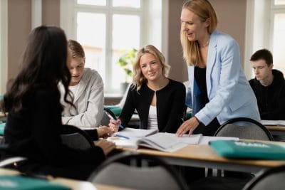 Elever i klassrum tillsammans med lärare.
