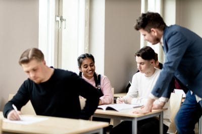 Lärare som hjälper elever i klassrum.