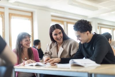 Elever skrattar tillsammans med lärare.