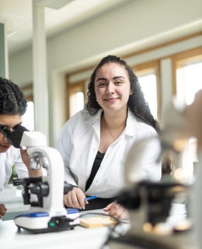 Elev är nöjd och har naturlaboration, tittar in i kameran och ler.