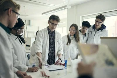 Lärare demonstrerar experiment för elever.