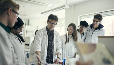 Lärare demonstrerar experiment för elever.