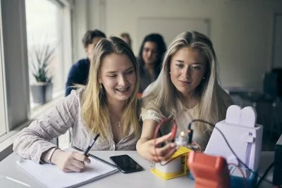 Två tjejer utför experiment med glödlampa.