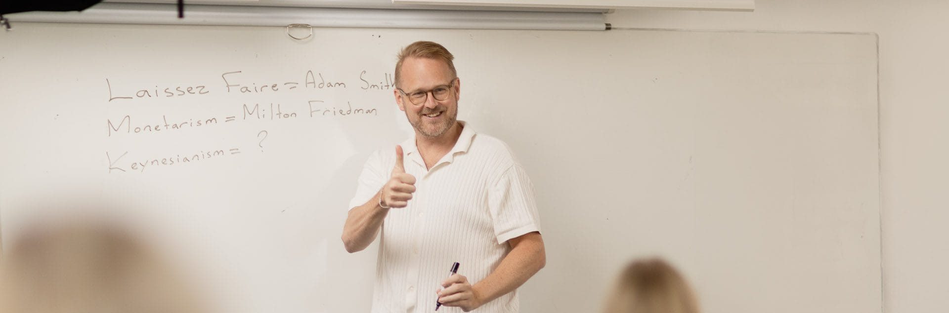 Lärare undervisar framme vid tavlan